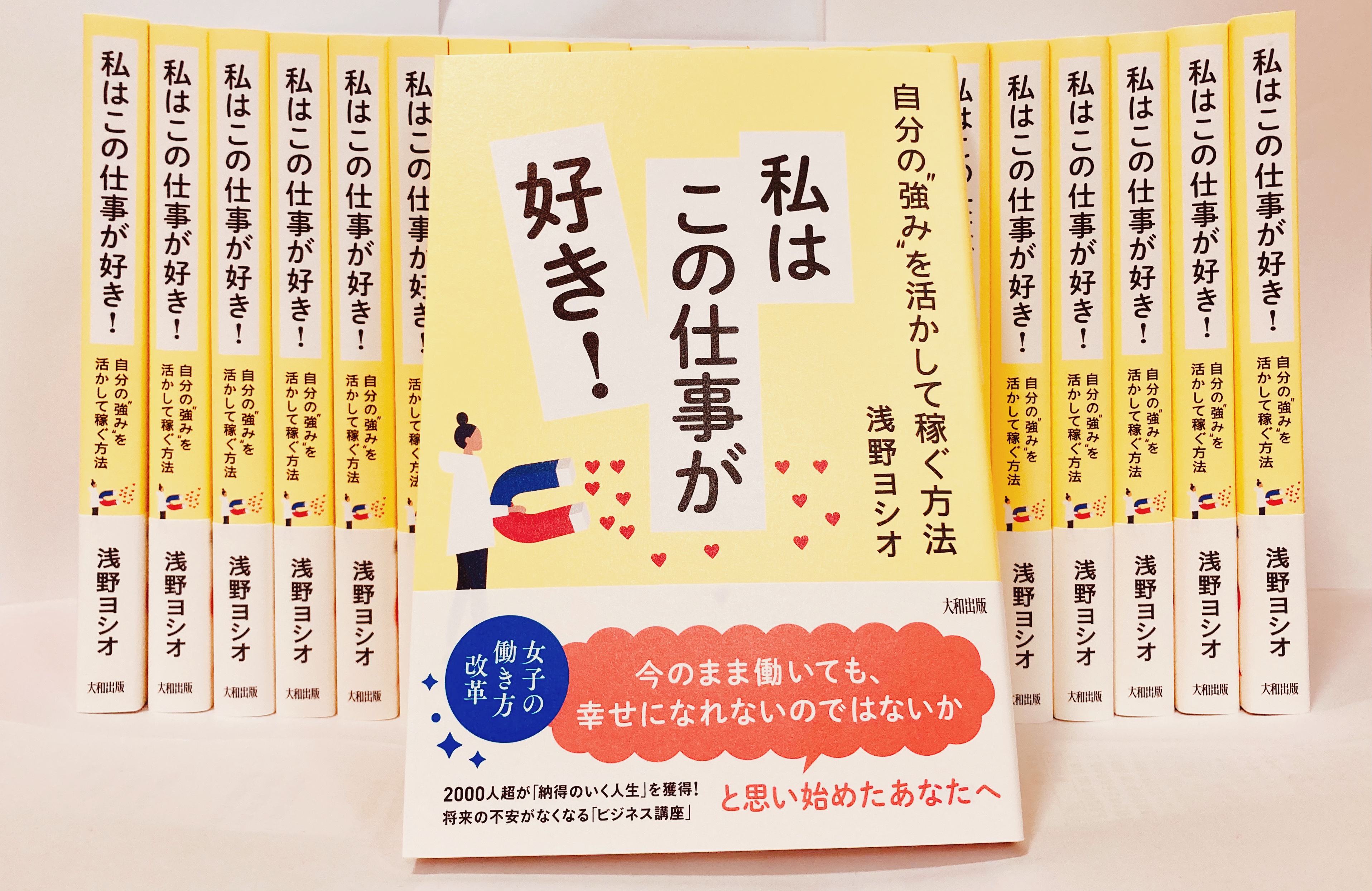 「自分の強みを活かして稼ぐ方法 私はこの仕事が好き!」著者：浅野ヨシオの背表紙が見える状態20冊並べ、その手前に本の表紙が見えるよう立てかけた状態
